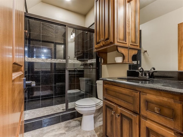 bathroom featuring vanity, a shower with shower door, and toilet