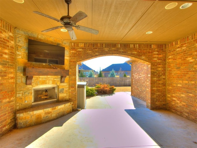 view of patio / terrace featuring ceiling fan and an outdoor stone fireplace