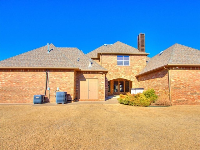 rear view of property with a yard, a patio area, and central air condition unit