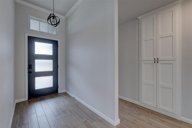 foyer with ornamental molding and light hardwood / wood-style flooring