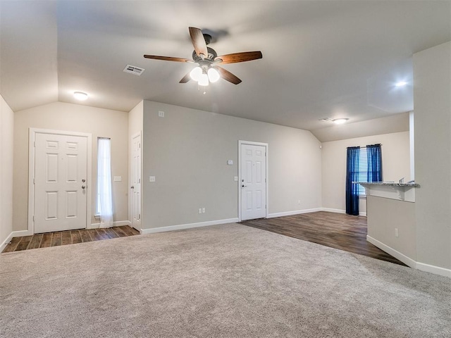 unfurnished living room featuring dark colored carpet, lofted ceiling, and ceiling fan