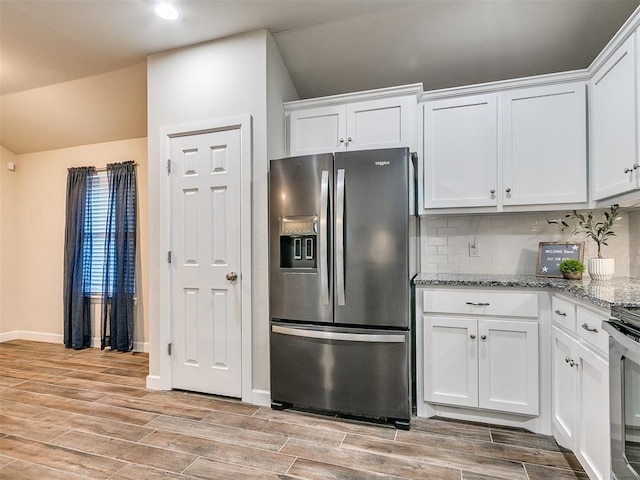 kitchen with light stone counters, backsplash, white cabinets, and appliances with stainless steel finishes