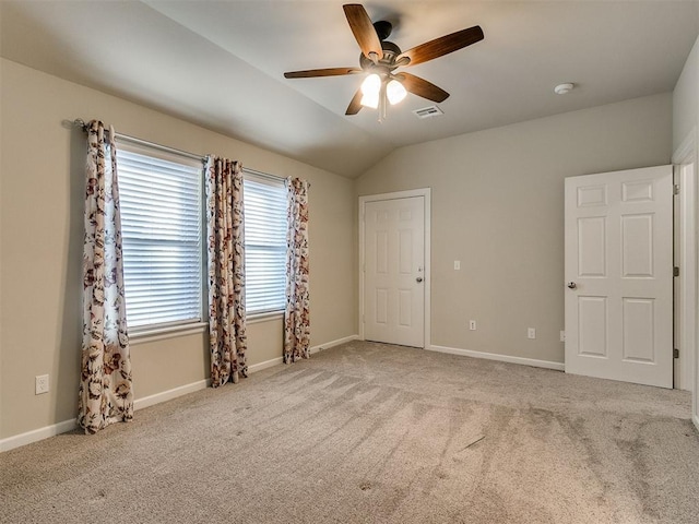 carpeted spare room featuring ceiling fan and lofted ceiling