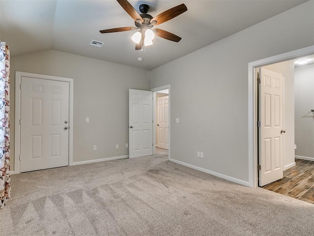 unfurnished bedroom with ceiling fan, light colored carpet, and lofted ceiling