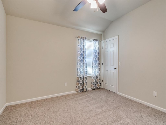 empty room featuring lofted ceiling, carpet floors, and ceiling fan