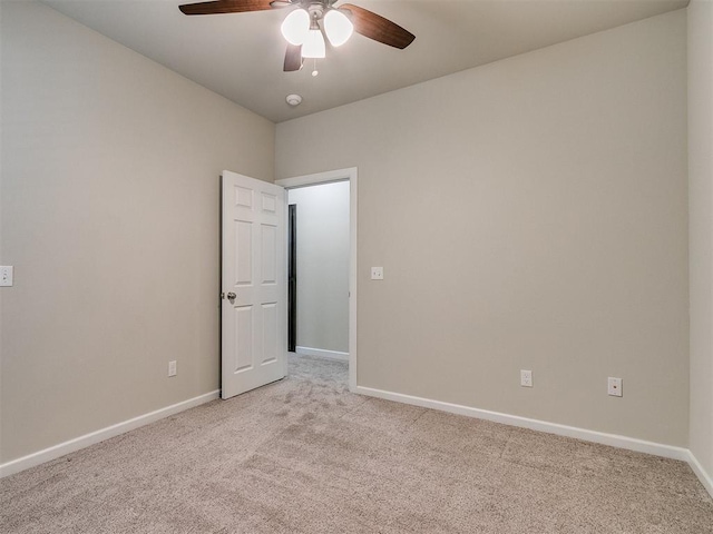 spare room with light colored carpet and ceiling fan