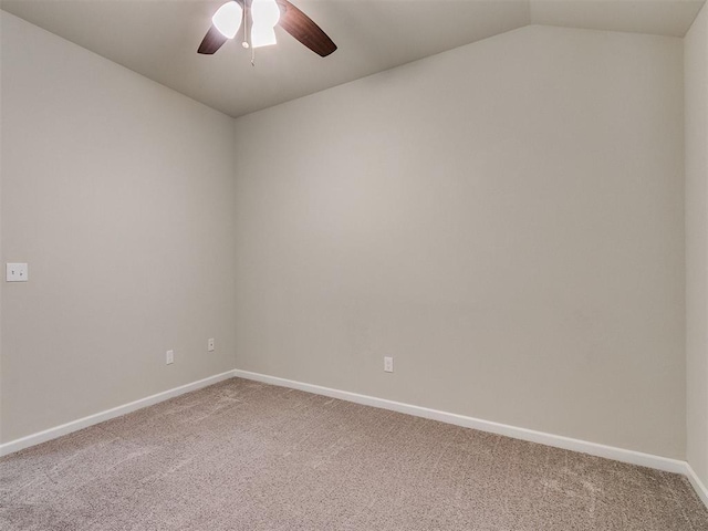 spare room with ceiling fan, vaulted ceiling, and carpet