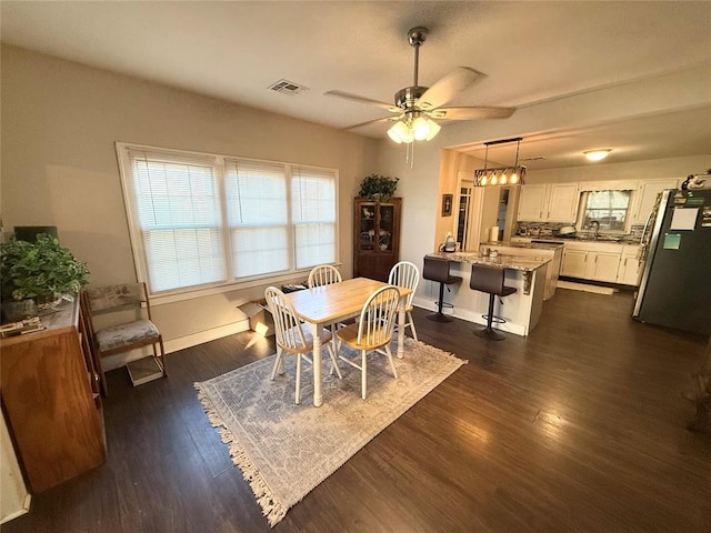 dining room with dark wood-type flooring, sink, and ceiling fan