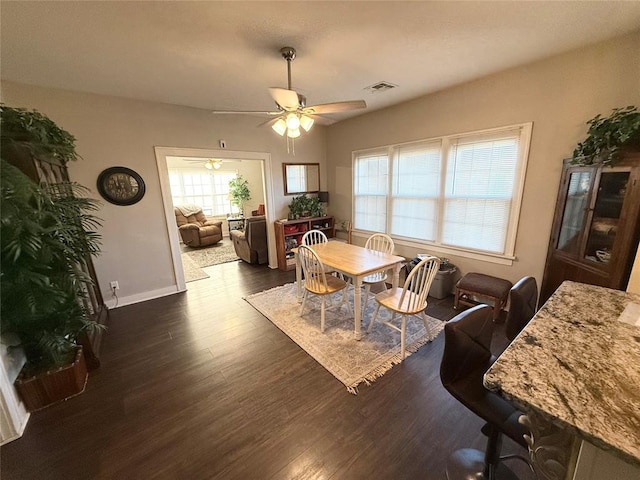 dining area with dark wood-type flooring and ceiling fan