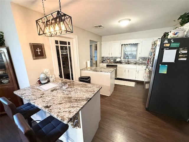 kitchen with a center island, hanging light fixtures, a kitchen breakfast bar, stainless steel appliances, and white cabinets