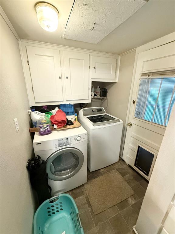 clothes washing area featuring independent washer and dryer, cabinets, and a textured ceiling