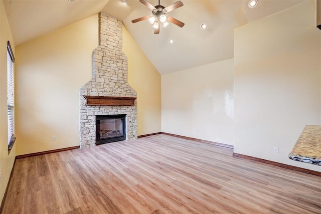 unfurnished living room with ceiling fan, a fireplace, high vaulted ceiling, and light hardwood / wood-style flooring