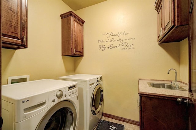 washroom with cabinets, washer and dryer, and sink