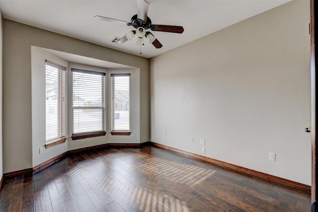 empty room featuring dark wood-type flooring and ceiling fan