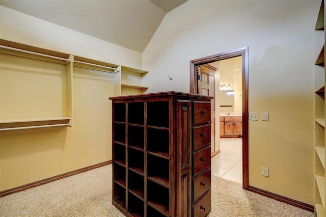 walk in closet featuring lofted ceiling and light carpet