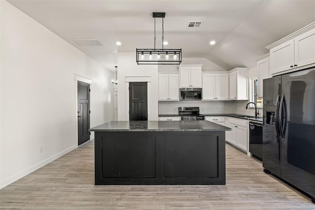 kitchen featuring white cabinets, black appliances, lofted ceiling, and a kitchen island