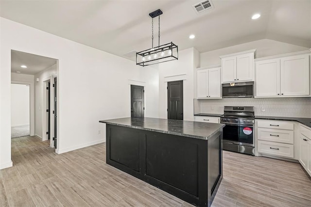 kitchen with white cabinets, appliances with stainless steel finishes, a kitchen island, hanging light fixtures, and vaulted ceiling