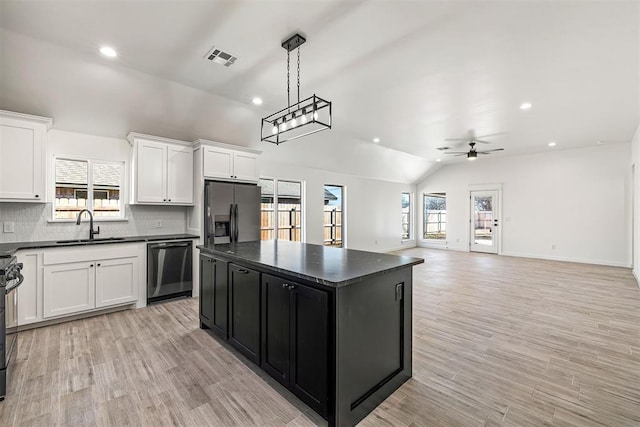 kitchen featuring a kitchen island, black dishwasher, stainless steel fridge with ice dispenser, vaulted ceiling, and ceiling fan