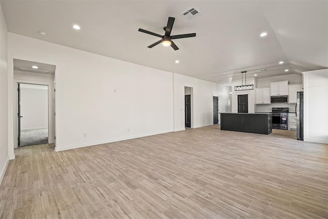 unfurnished living room featuring ceiling fan, vaulted ceiling, and light hardwood / wood-style floors