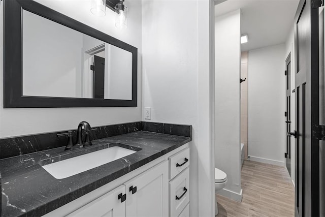 full bathroom featuring hardwood / wood-style floors, toilet, vanity, and  shower combination