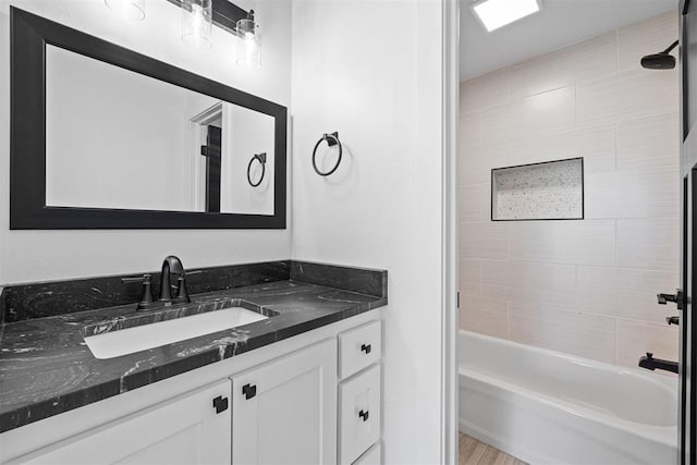 bathroom featuring tiled shower / bath and vanity