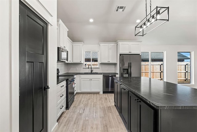202 E Main St, Calumet, OK 73014 - kitchen featuring appliances with stainless steel finishes, dark countertops, a sink, light wood finished floors, and recessed lighting