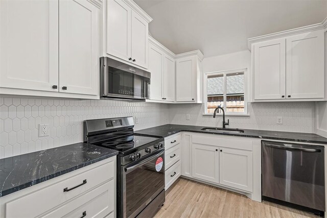 202 E Main St, Calumet, OK 73014 - kitchen with appliances with stainless steel finishes, a sink, white cabinets, light wood finished floors, and dark stone countertops