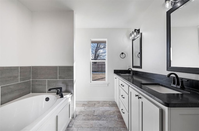 202 E Main St, Calumet, OK 73014 - full bath with double vanity, a bath, baseboards, and stone finish floors