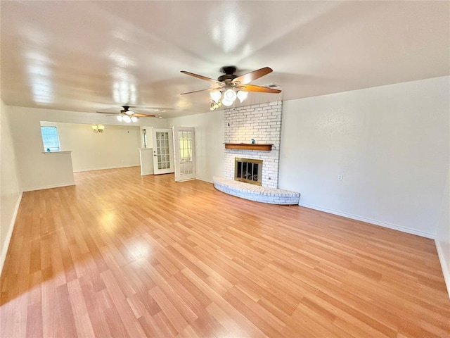 unfurnished living room with light hardwood / wood-style flooring, a fireplace, and ceiling fan