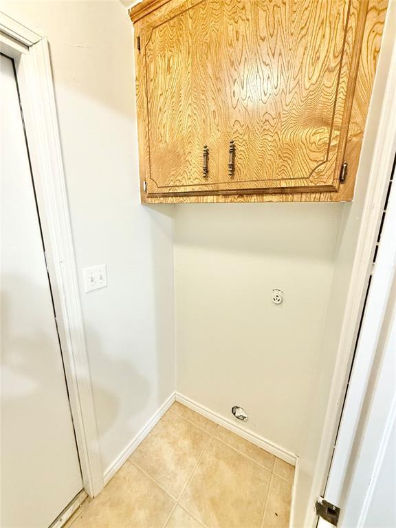 laundry room with cabinets and light tile patterned floors