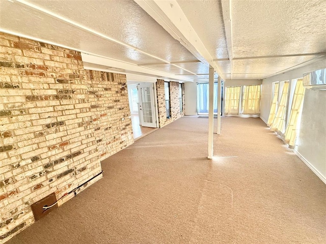 basement featuring brick wall and a textured ceiling