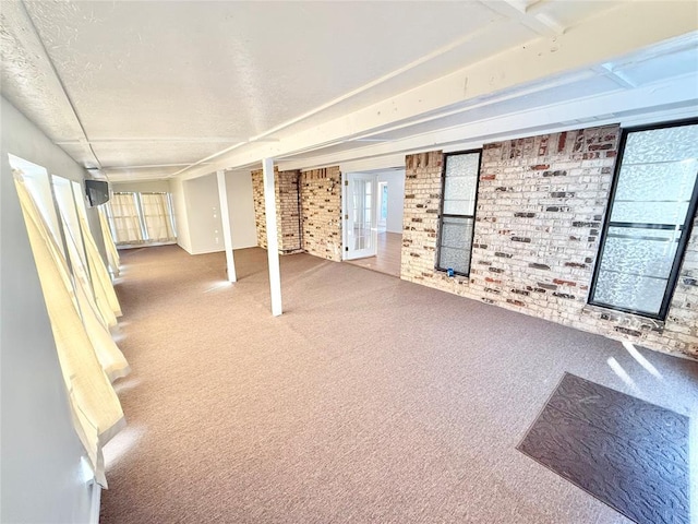 basement featuring brick wall, carpet flooring, and french doors