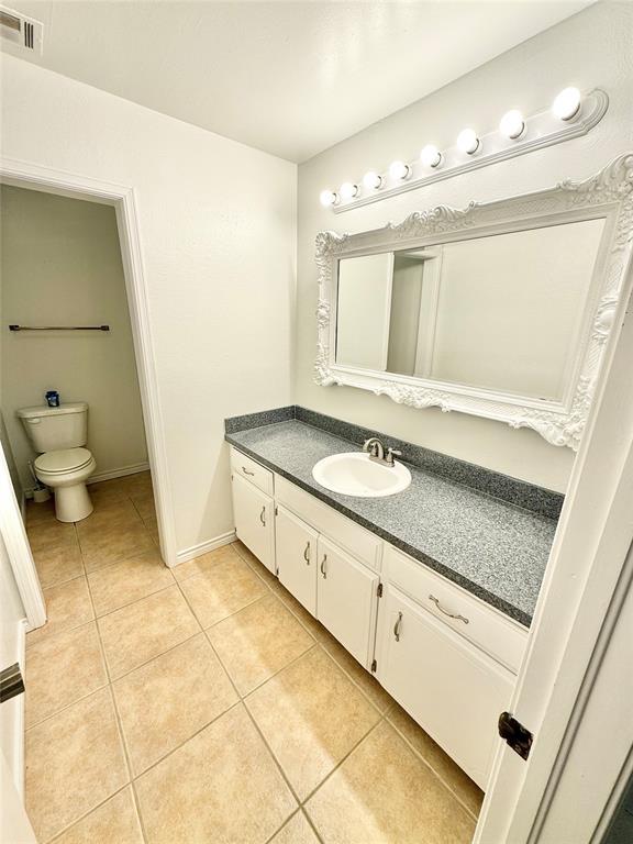 bathroom with vanity, toilet, and tile patterned flooring