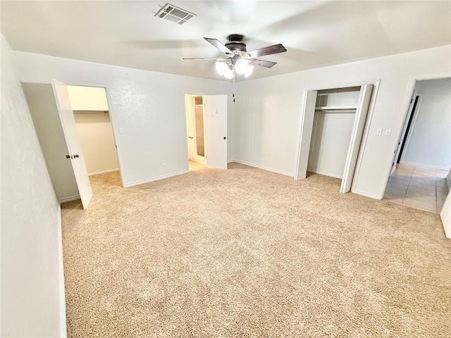 unfurnished bedroom featuring light colored carpet, ceiling fan, and a closet