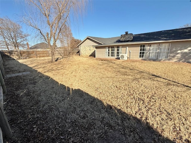 rear view of property featuring ac unit and a lawn