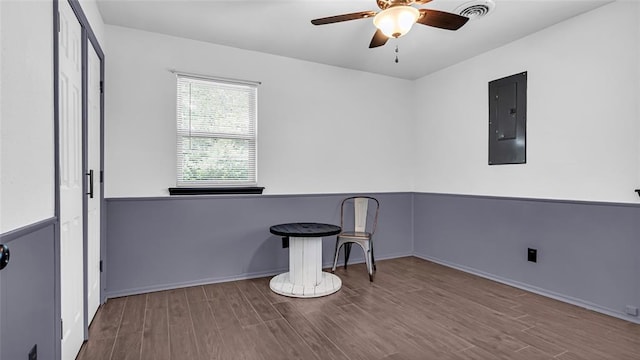 interior space with electric panel, ceiling fan, and hardwood / wood-style flooring