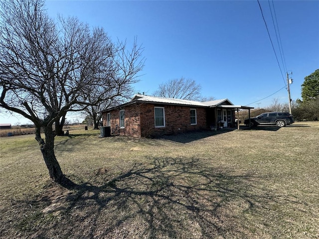 view of side of property featuring brick siding and a lawn