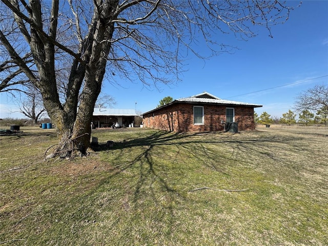 exterior space featuring brick siding and a lawn