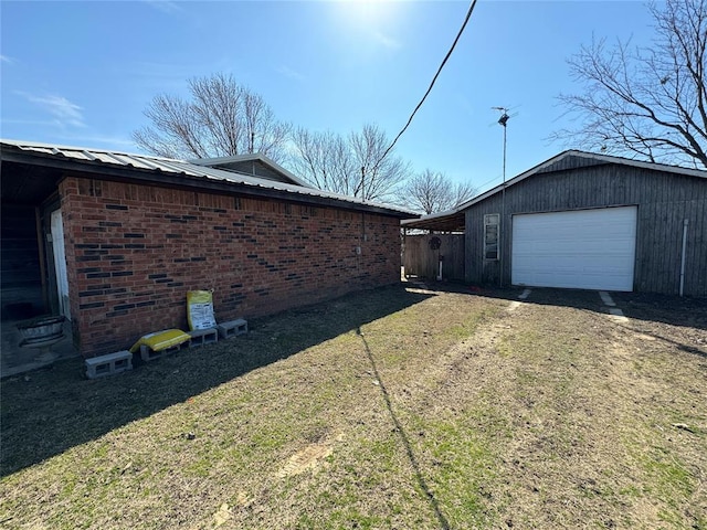 view of side of property with a garage, dirt driveway, metal roof, and brick siding