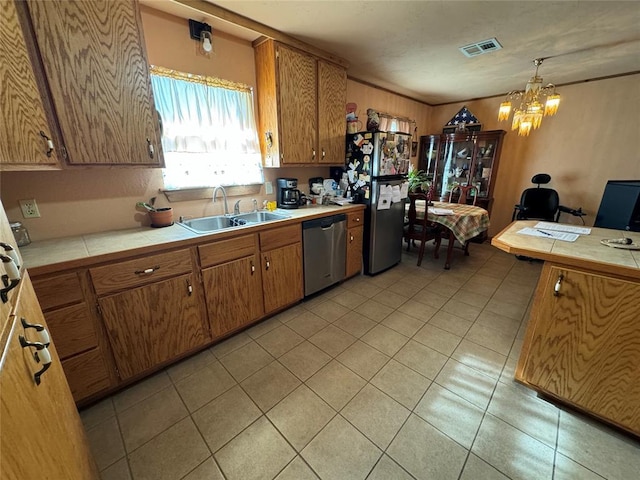 kitchen with visible vents, tile counters, brown cabinets, stainless steel appliances, and a sink