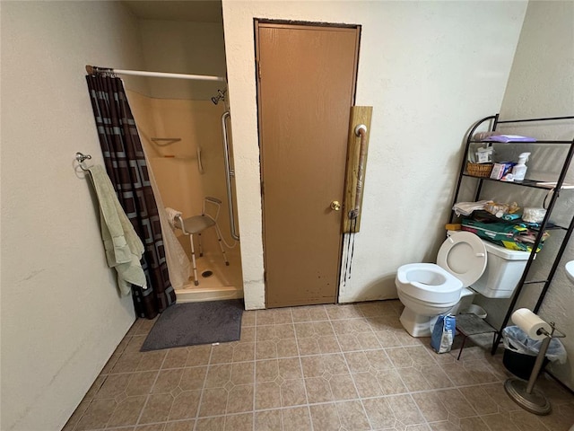 bathroom featuring tile patterned flooring, a shower stall, and toilet