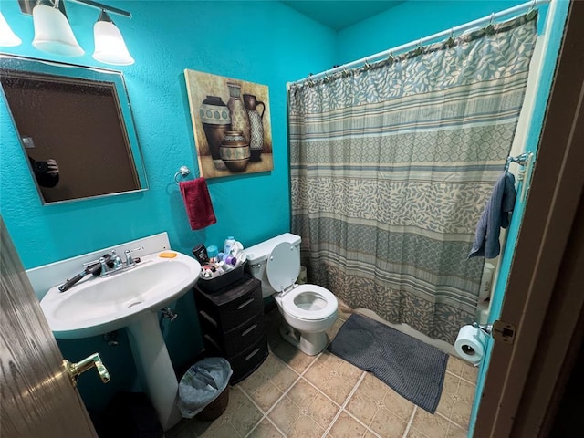 full bath with a shower with curtain, a sink, toilet, and tile patterned floors