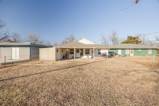 rear view of house with a patio and a yard