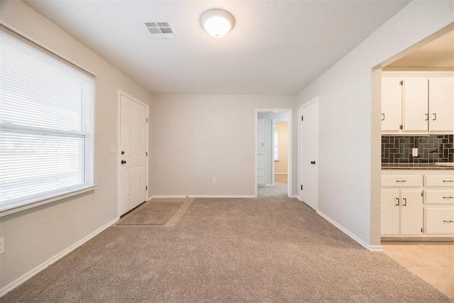 unfurnished room featuring light carpet