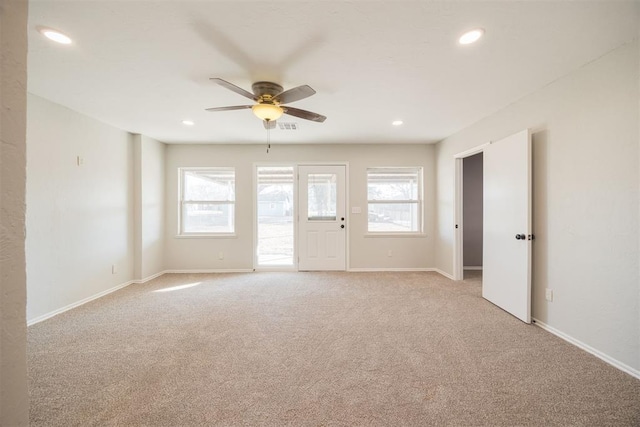 spare room with ceiling fan and light carpet