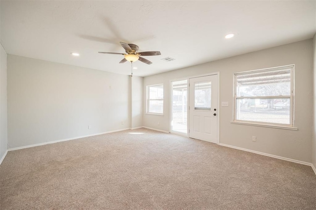 spare room with ceiling fan and light carpet