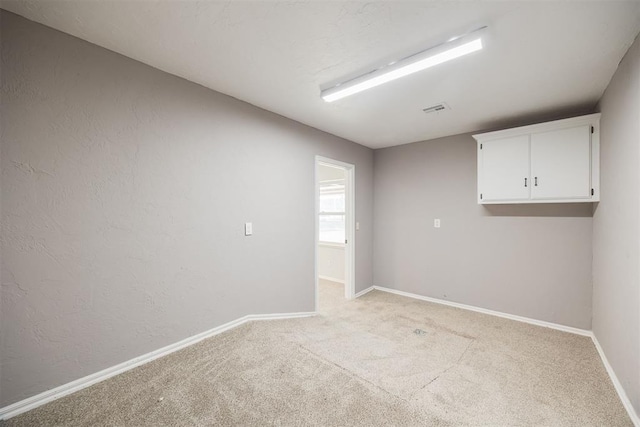 spare room featuring light colored carpet