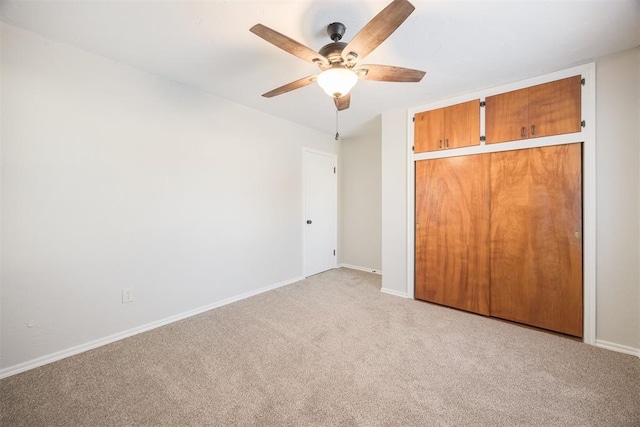 unfurnished bedroom with light carpet, a closet, and ceiling fan