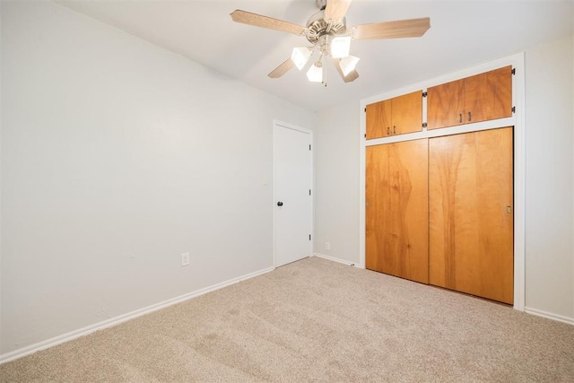 unfurnished bedroom featuring light colored carpet, ceiling fan, and a closet