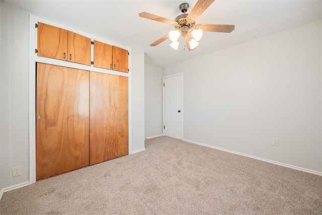 unfurnished bedroom with ceiling fan, a closet, and light carpet